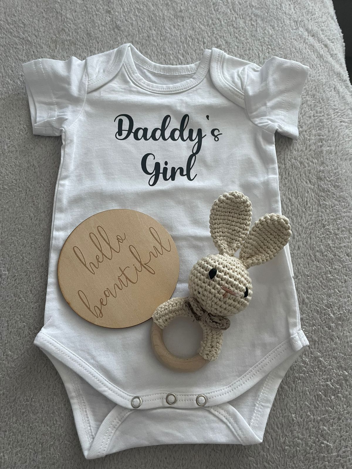white personalised baby onesie with wooden sign and rabbit teether